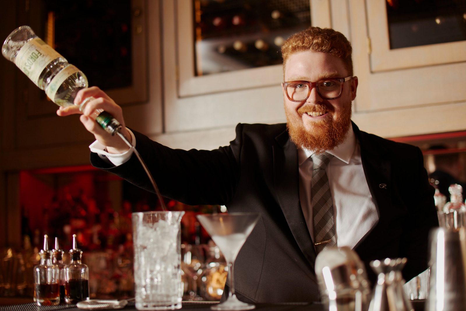 Samuel Slaughter behind the bar, pouring gin from height